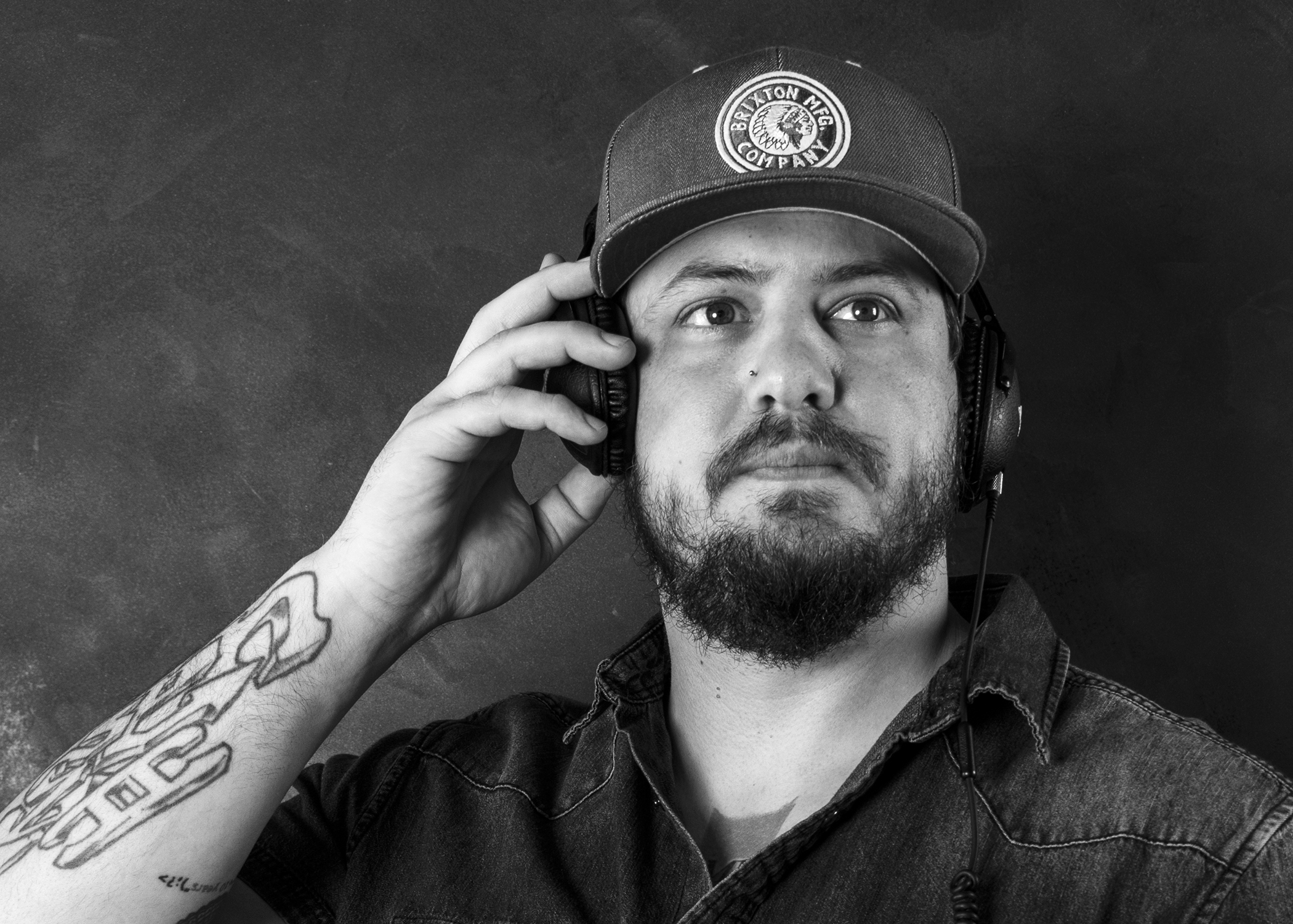Black and white portrait of Bear Cole listening through headphones